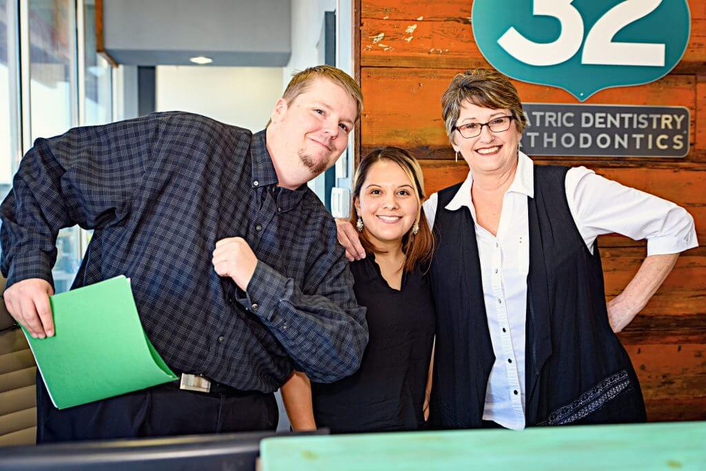 Three office team members of Route 32 Dental in the office reception area